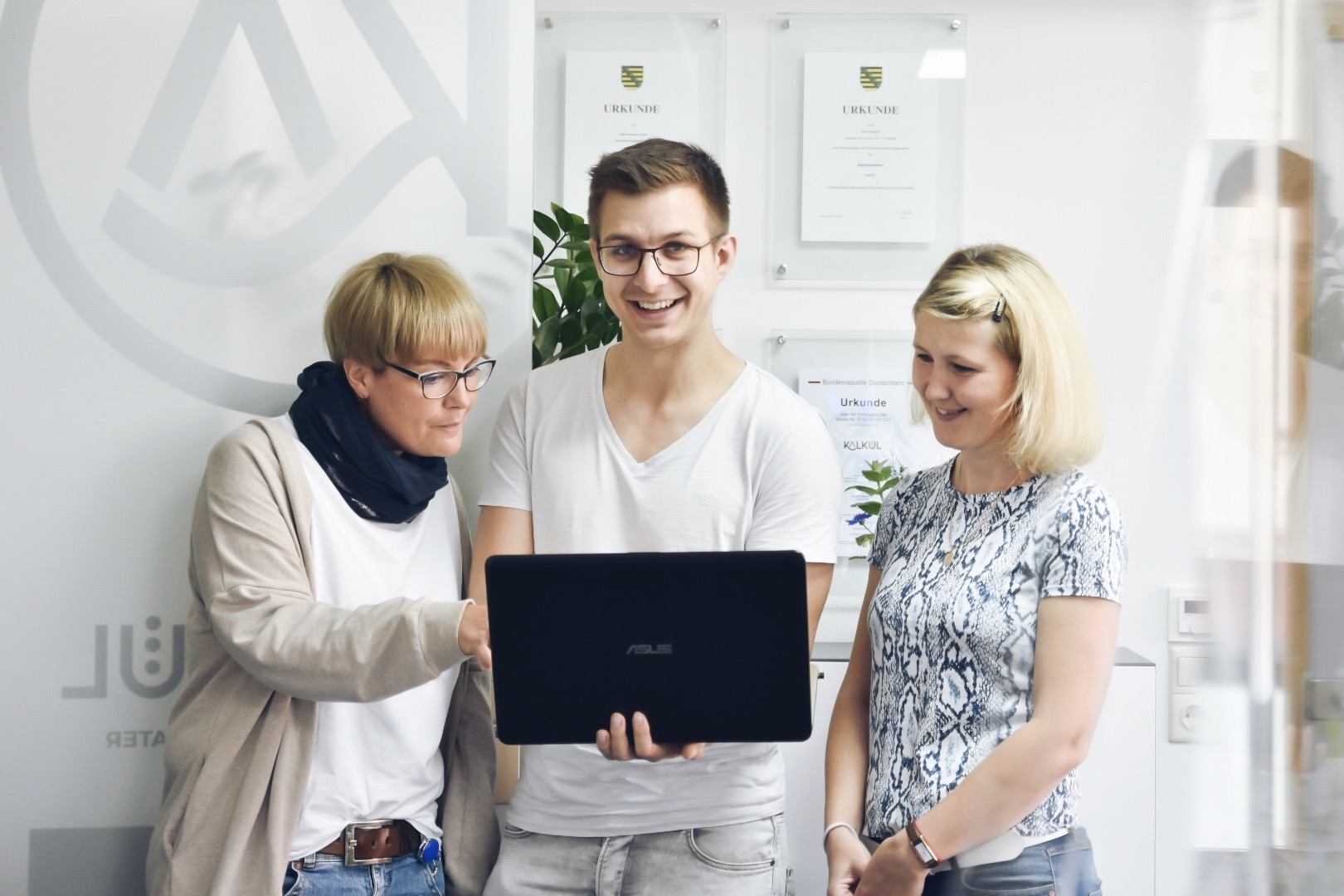Mitarbeiter von kalkül erklärt Kollegen etwas am Laptop
